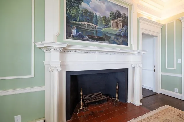 a living room with a fireplace and a painting on the wall