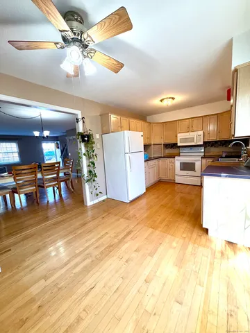 a kitchen with stainless steel appliances kitchen island granite countertop a table chairs and a refrigerator