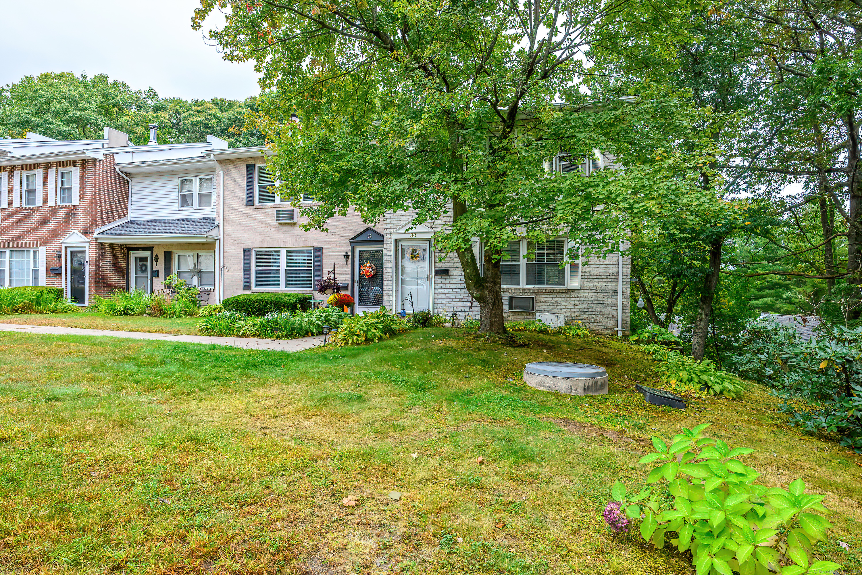 38 Surrey Lane, Unit 38 Torrington, CT 06790 - Photo 20 of 24 a front view of a house with a yard and trees