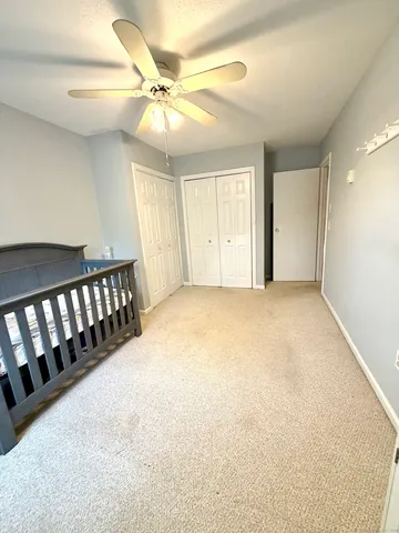 an empty room with windows and fan