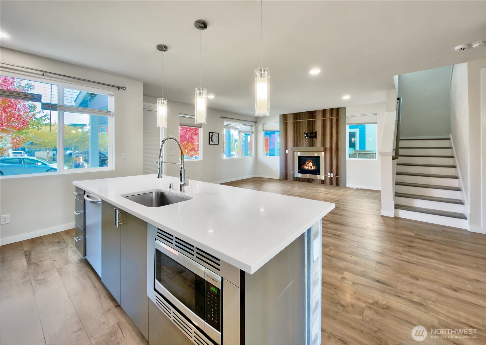 9849 6th Place Southwest Seattle, WA 98106 - Photo 5 of 21 a kitchen with stainless steel appliances granite countertop a sink dishwasher and a fireplace with wooden floor