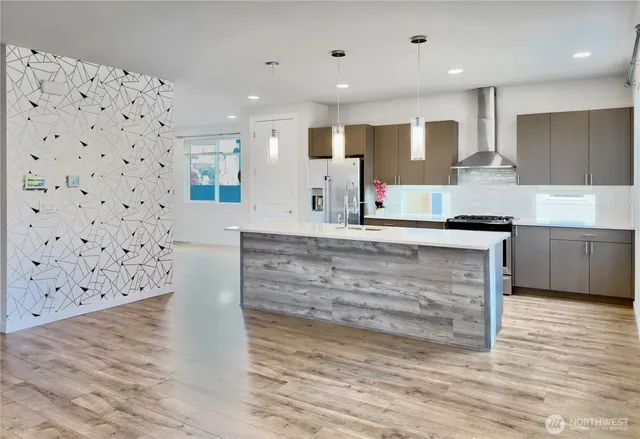 a large kitchen with kitchen island a sink stainless steel appliances and cabinets