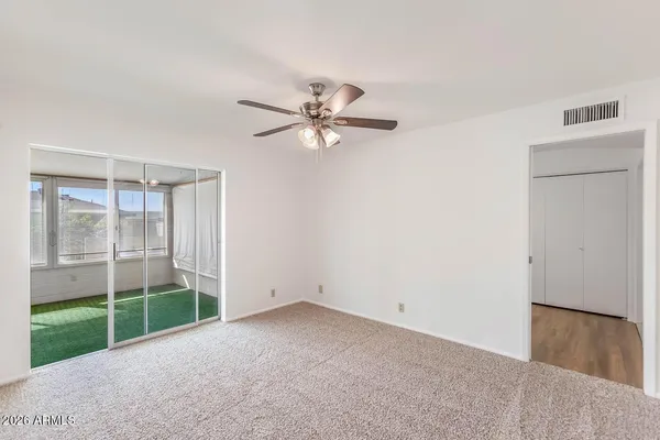 a view of a room with a ceiling fan and a window