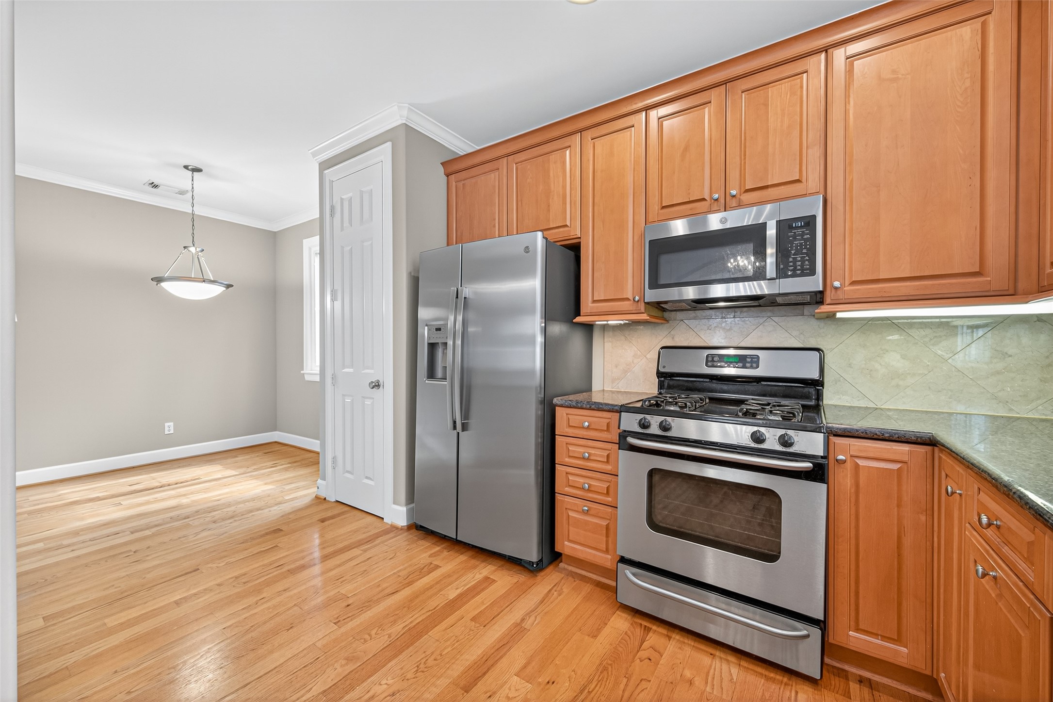 2624 Helena Street Houston, TX 77006 - Photo 15 of 33 a kitchen with stainless steel appliances wooden cabinets stove and microwave