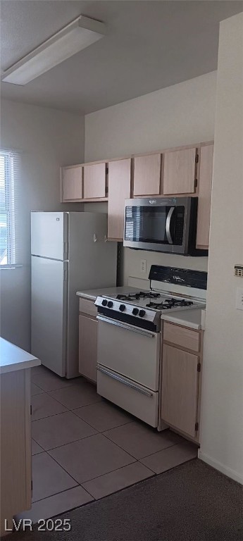 7413 West Russell Road, Unit 107 Las Vegas, NV 89113 - Photo 11 of 48 Kitchen featuring white appliances, light countertops, light brown cabinets, and light tile patterned floors