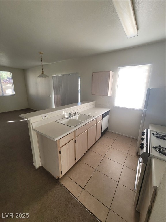 7413 West Russell Road, Unit 107 Las Vegas, NV 89113 - Photo 21 of 48 Kitchen featuring a sink, a peninsula, light countertops, and light brown cabinets