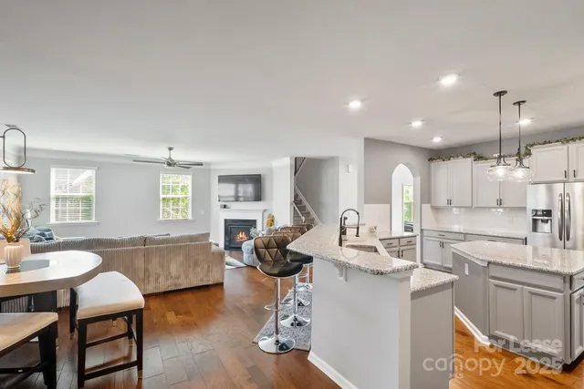 a very nice looking open dining room with kitchen island stainless steel appliances a table and chairs