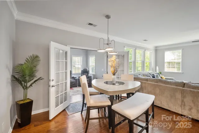 a view of a a dining room with furniture window and wooden floor