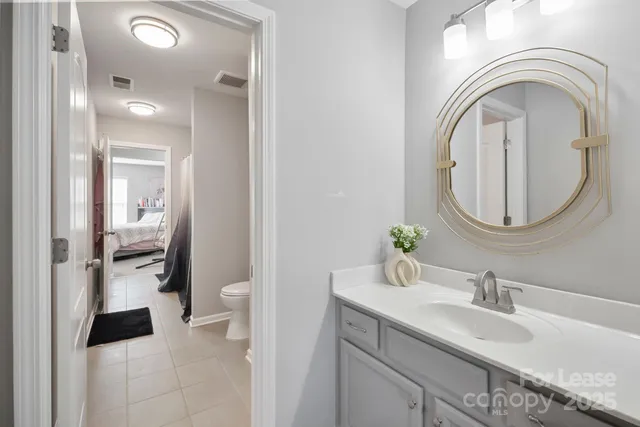 a bathroom with a sink a toilet and a mirror