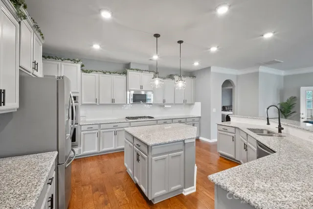 a large kitchen with stainless steel appliances granite countertop a counter top and stove