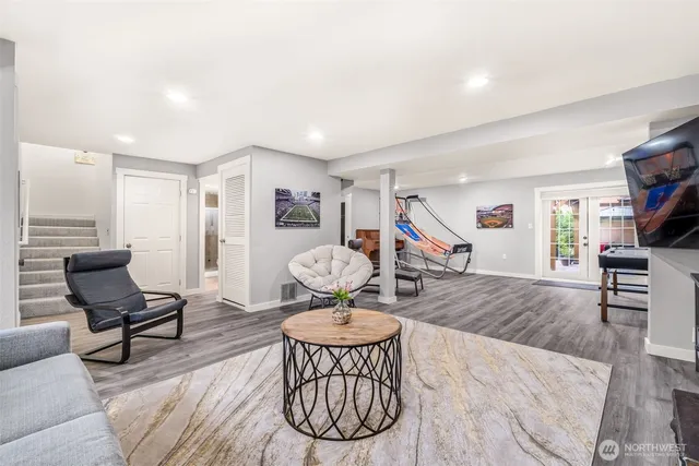 a living room with furniture a rug and a wooden floor