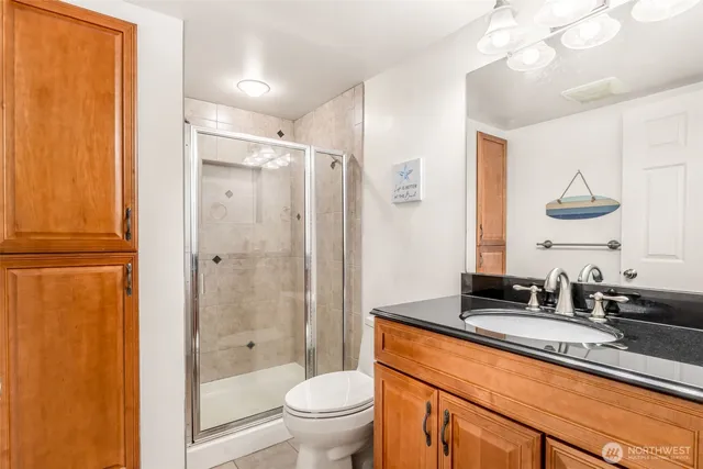 a bathroom with a granite countertop sink toilet and shower