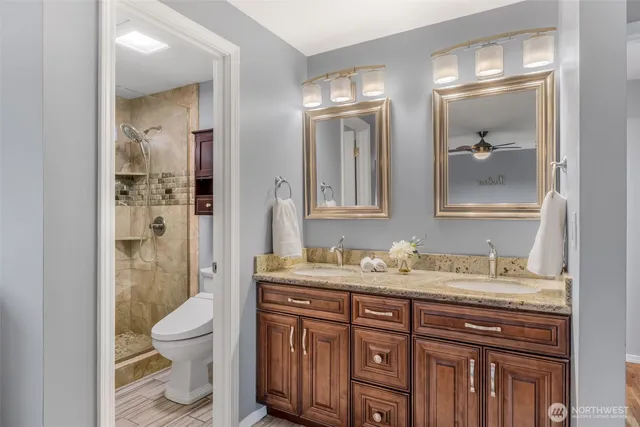 a bathroom with a sink a toilet and shower