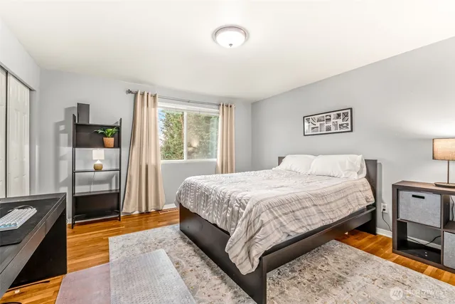 a bedroom with a bed and wooden floor