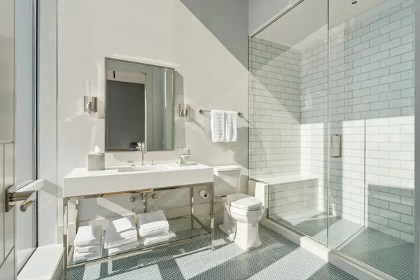 a bathroom with a sink mirror and a toilet