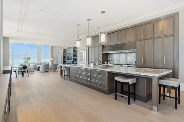 a kitchen with stainless steel appliances kitchen island granite countertop a table chairs sink and cabinets