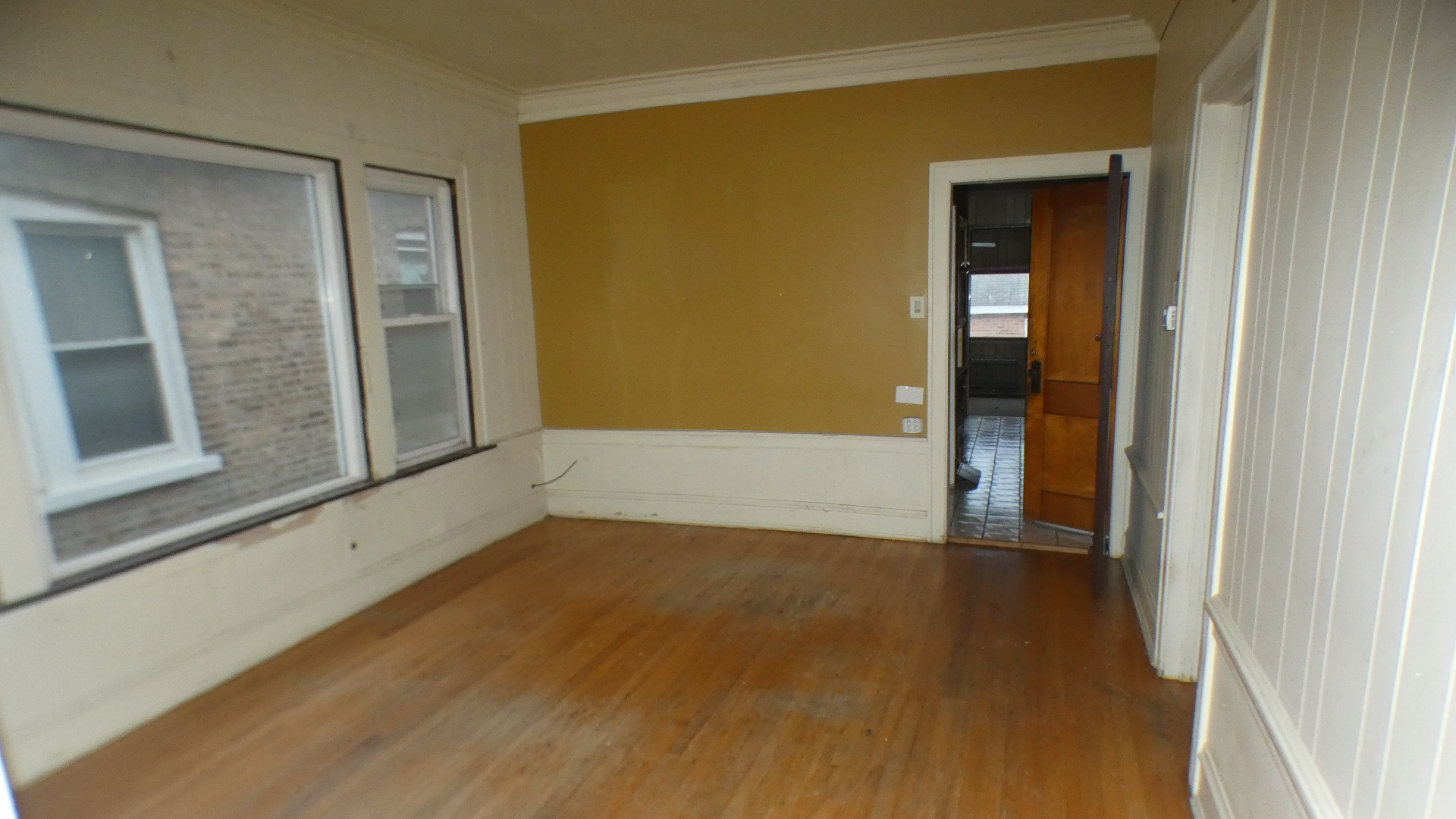 8133 South Loomis Boulevard Chicago, IL 60620 - Photo 5 of 32 a view of an empty room with wooden floor and a window