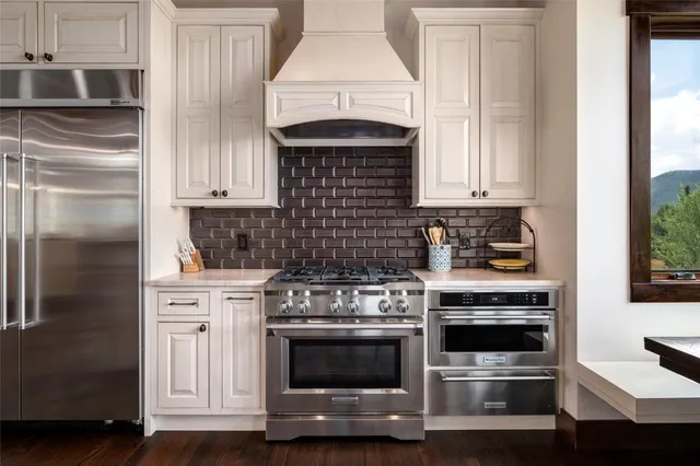 a kitchen with granite countertop white cabinets and stainless steel appliances