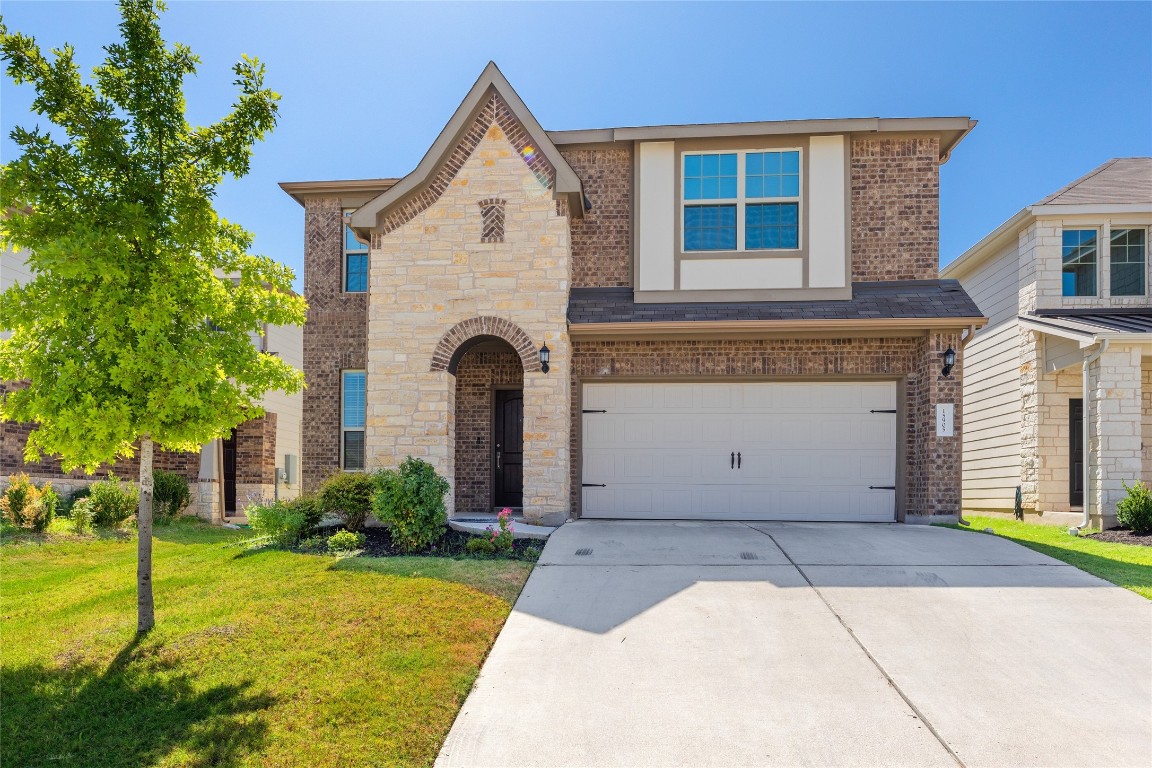 a front view of a house with a yard and garage