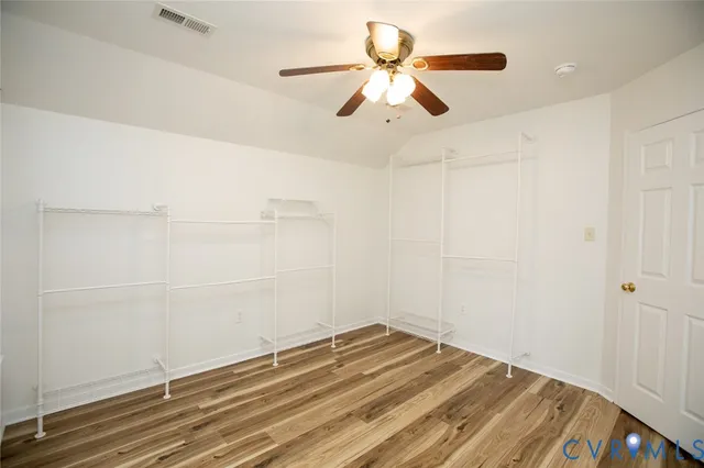 a view of a room with wooden floor and fan