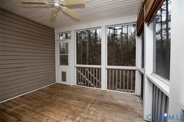 a view of a porch with wooden floor and floor to ceiling window