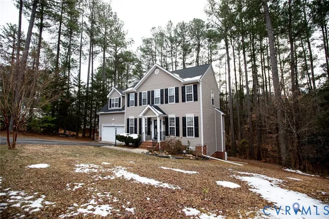 a front view of a house with a yard and large trees