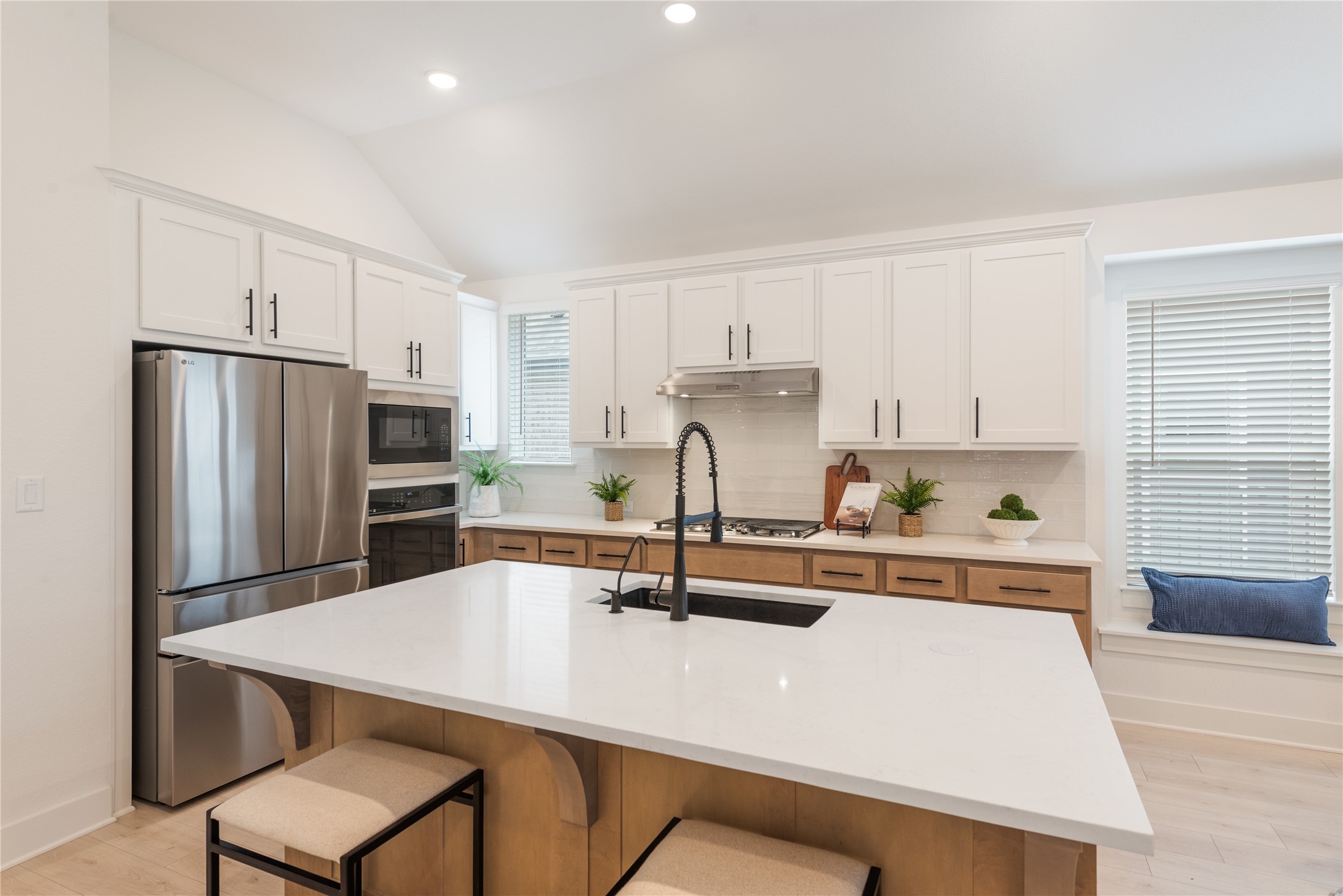 294 Kimble Creek Loop Kyle, TX 78640 - Photo 4 of 40 This kitchen showcases a central island with sleek white countertops, ideal for meal preparation and casual dining.