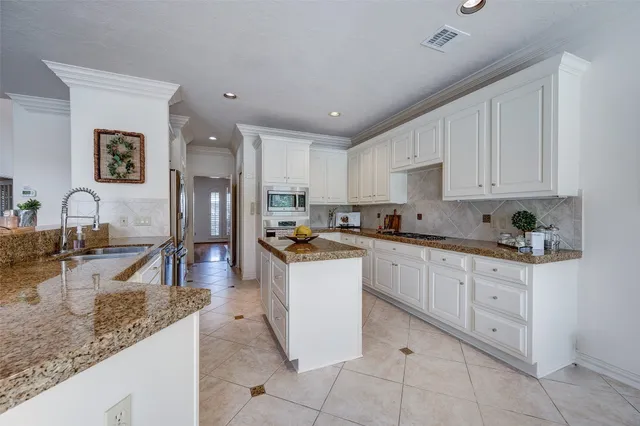 a kitchen with granite countertop sink and cabinets
