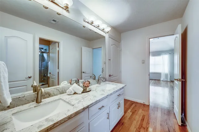 a bathroom with a granite countertop sink and a mirror