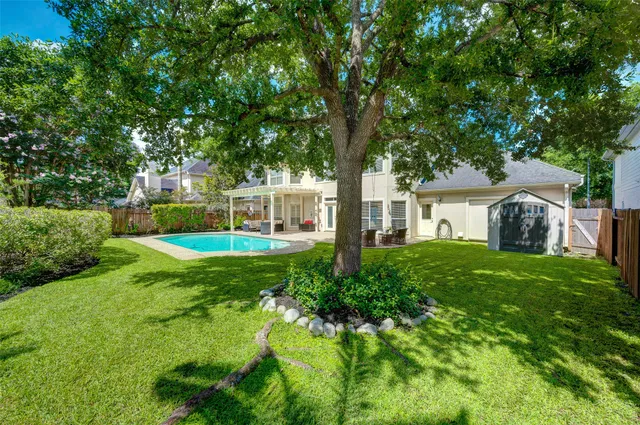 a view of a house with backyard and a tree