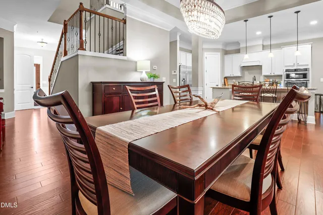 a dining hall with stainless steel appliances a dining table and chairs with wooden floor