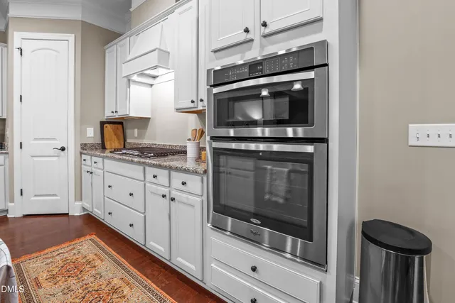 a kitchen with granite countertop cabinets stainless steel appliances and a counter space