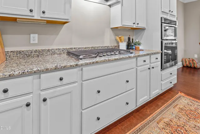a kitchen with granite countertop white cabinets and white appliances