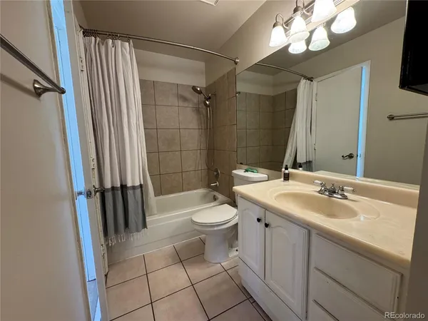a bathroom with a sink a toilet a mirror and shower