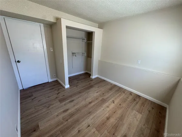 an empty room with wooden floor and entrance