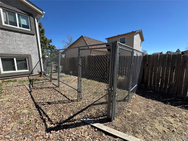 a view of a house with wooden fence
