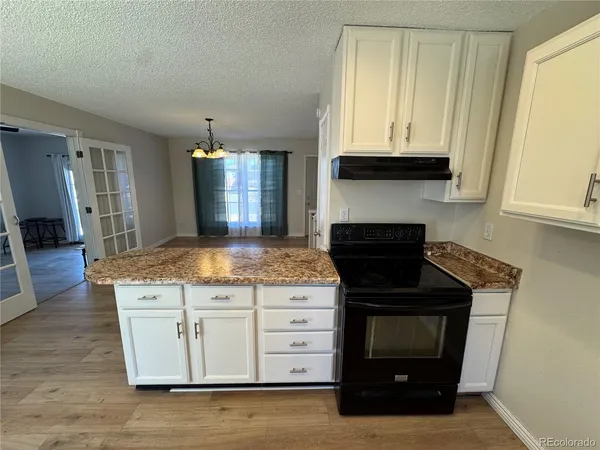 a kitchen with granite countertop a stove and a sink