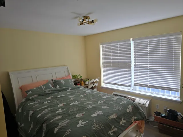 a bed sitting in a bedroom next to a window