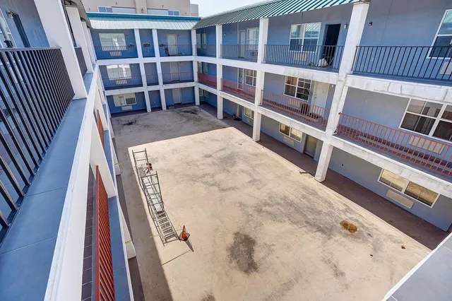 a view of an empty room with wooden floor and a stairs