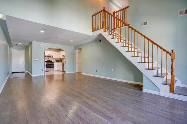 a view of a hallway with wooden floor and stairs