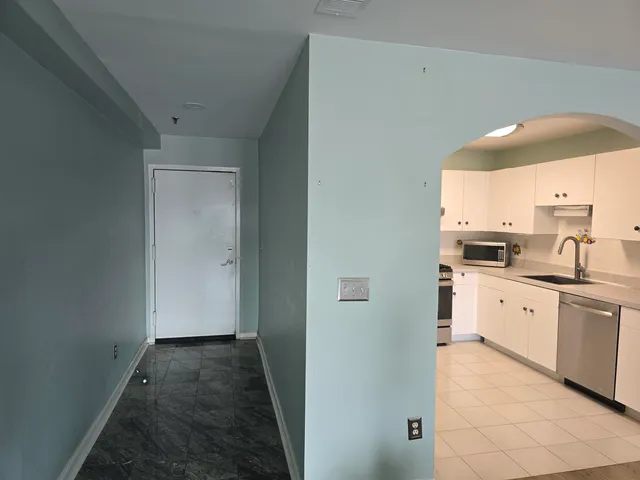 a kitchen with granite countertop a sink and white cabinets
