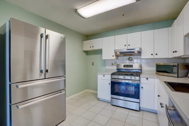 a kitchen with stainless steel appliances granite countertop a refrigerator sink and stove