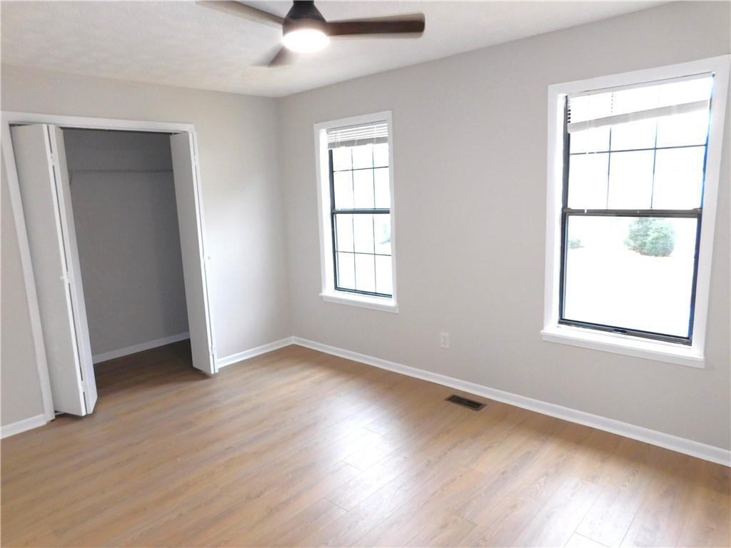3589 North Hopkins Court Powder Springs, GA 30127 - Photo 13 of 17 an empty room with wooden floor and windows
