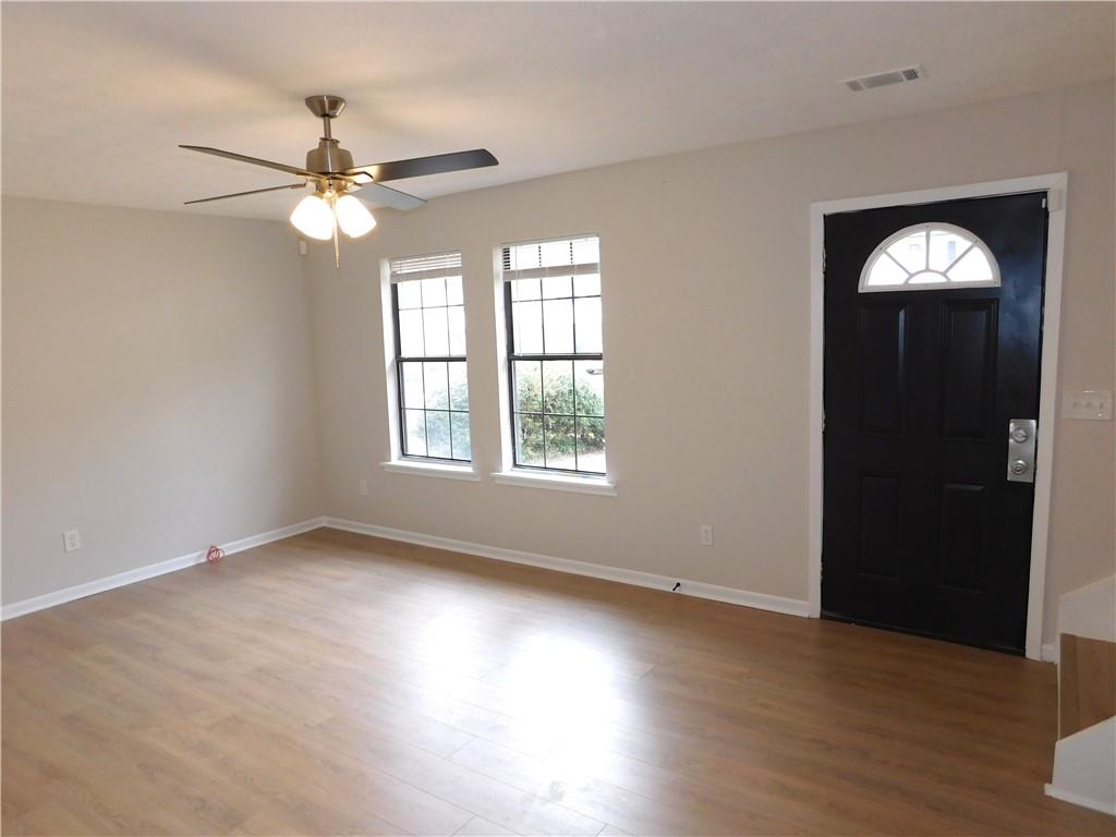 3589 North Hopkins Court Powder Springs, GA 30127 - Photo 3 of 17 an empty room with wooden floor fan and windows