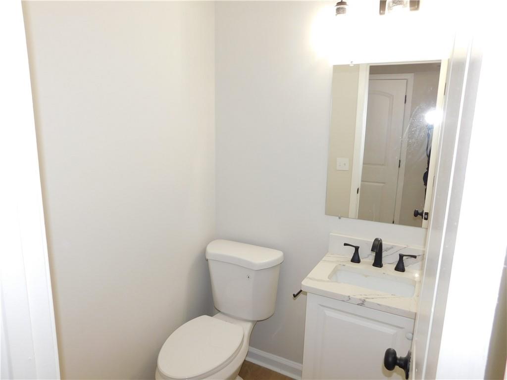 3589 North Hopkins Court Powder Springs, GA 30127 - Photo 5 of 17 a bathroom with a toilet sink vanity and mirror