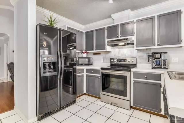 a kitchen with stainless steel appliances granite countertop a refrigerator and a stove top oven
