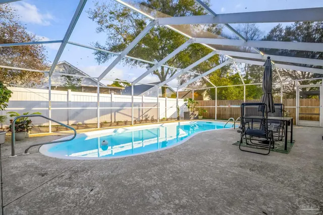 a view of a swimming pool with a patio and a yard