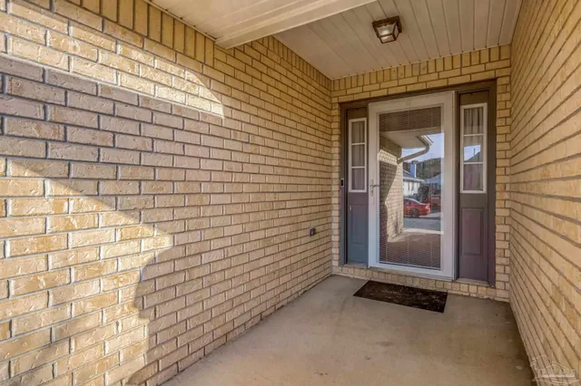 a view of a white house with large trees and plants