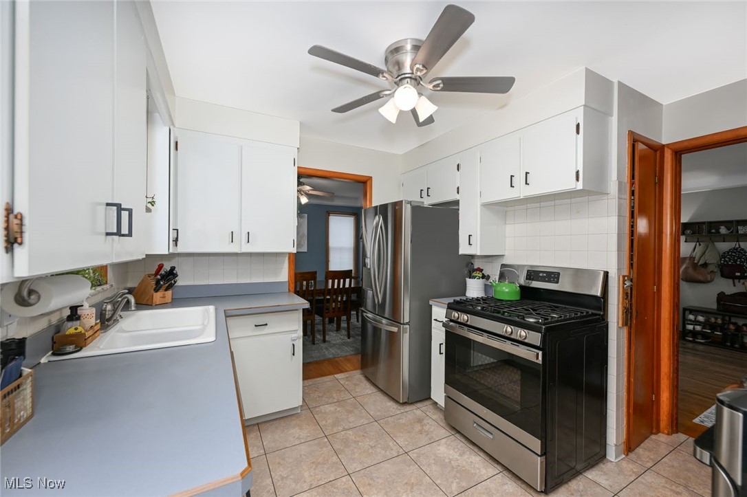 4940 Westbourne Road Cleveland, OH 44124 - Photo 9 of 26 Kitchen with white cabinets, decorative backsplash, light hardwood / wood-style floors, and stainless steel appliances
