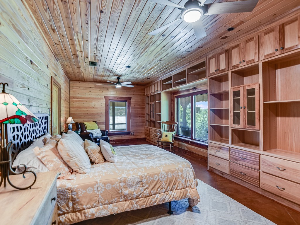 254 Middleton Road Spicewood, TX 78669 - Photo 16 of 32 a bedroom with a large bed and windows